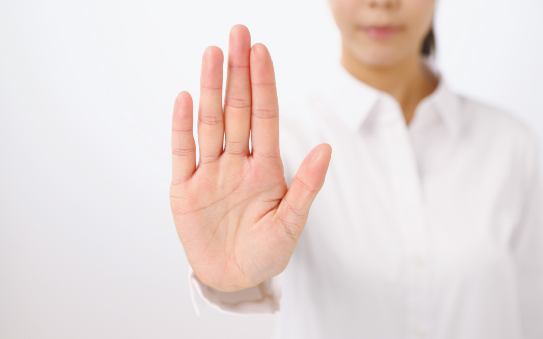 Hand mit Stoppgeste als Symbol für klare Grenzen im Lehrer:innenalltag